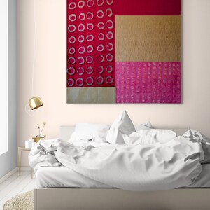 May include: Abstract art painting with a red, gold, and pink color scheme. The painting features a geometric design with circles and squares.