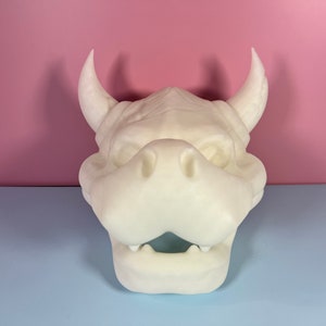 Puede incluir: M&aacute;scara de cabeza de drag&oacute;n blanca, impresa en 3D, sin pintar, con cuernos. La m&aacute;scara tiene una boca abierta con dientes y una nariz grande y redonda.