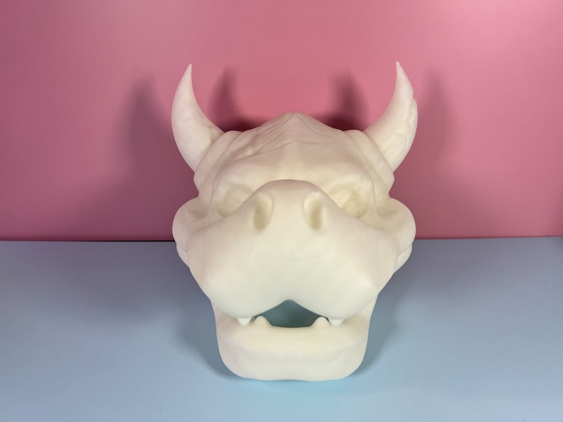 Puede incluir: M&aacute;scara de cabeza de drag&oacute;n blanca, impresa en 3D, sin pintar, con cuernos. La m&aacute;scara tiene una boca abierta con dientes y una nariz grande y redonda.