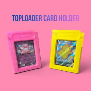 May include: Pink and yellow card holders with the text "CARD BOY" and "TOPLOADER CARD HOLDER". Each holder contains a trading card. The pink holder has a Clefairy card, and the yellow holder has a Pikachu card.