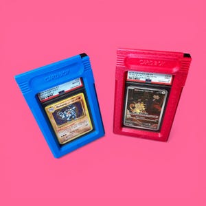 May include: Two trading card holders, one blue and one red, each containing a Pok&eacute;mon card. The blue holder displays a Machamp card, while the red holder features a Team Rocket's Meowth card. The holders are labeled "CARD BOY".