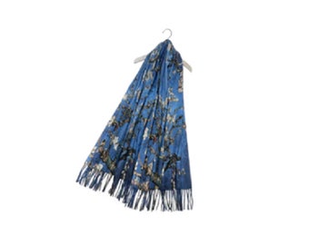 Puede incluir: Una bufanda azul con estampado floral y flecos. La bufanda está colgada de una percha.