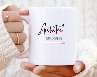 May include: White ceramic mug with black text that reads "Architect in progress" with a pink progress bar underneath.