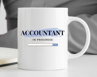 Op de afbeelding: Een witte keramische mok met een blauw-wit ontwerp. De mok heeft de tekst "Accountant in progress" met een bijna volle voortgangsbalk.