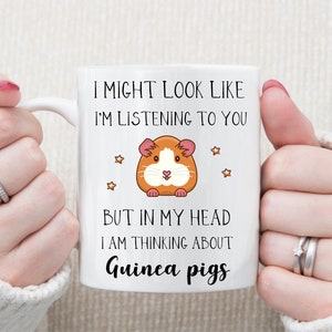 May include: White ceramic mug with a black and orange cartoon guinea pig and the text "I might look like I'm listening to you, but in my head I am thinking about guinea pigs."