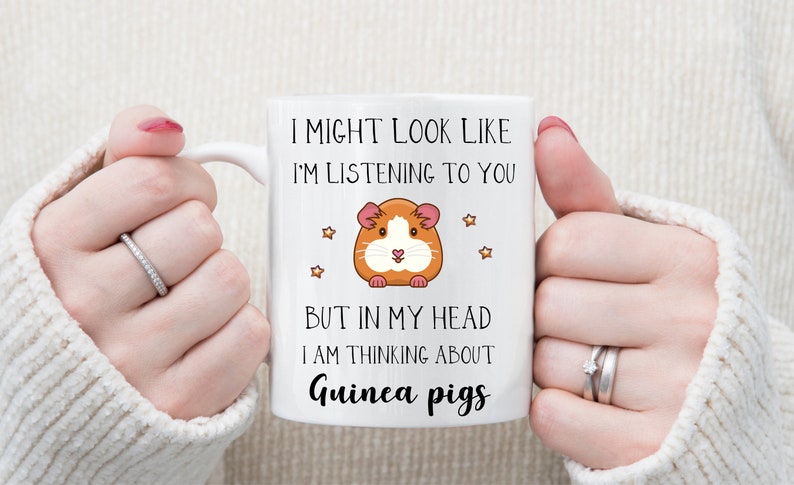 May include: White ceramic mug with a black and orange cartoon guinea pig and the text "I might look like I'm listening to you, but in my head I am thinking about guinea pigs."