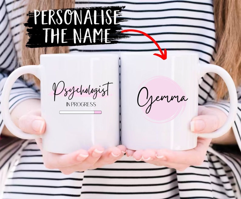 Puede incluir: Taza de cer&aacute;mica blanca con un c&iacute;rculo rosa y el texto "Gemma" en un lado y el texto "Psic&oacute;logo en progreso" con una barra de progreso rosa en el otro lado.