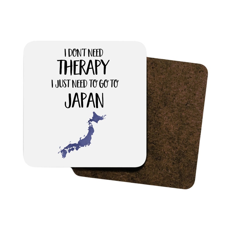 May include: White coaster with black text that reads "I don't need therapy I just need to go to Japan" with a blue outline of the country of Japan.