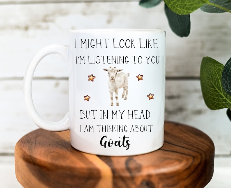 May include: White ceramic coffee mug with a black and white illustration of a goat and the text "I might look like I'm listening to you but in my head I am thinking about Goats".