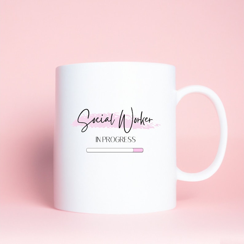Puede incluir: Taza de cer&aacute;mica blanca con un dise&ntilde;o en negro y rosa que dice "Social Worker In Progress" con una barra de progreso debajo.