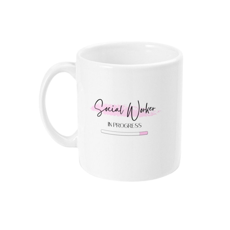 Puede incluir: Taza de cer&aacute;mica blanca con un dise&ntilde;o rosa y negro que dice "Social Worker In Progress" con una barra de progreso.