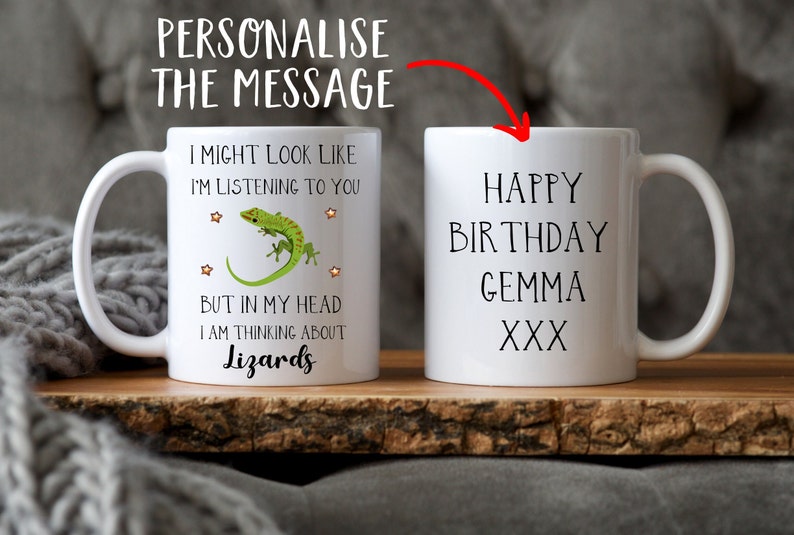 Pu&ograve; includere: Due tazze in ceramica bianca. Una tazza presenta una lucertola verde con stelle e il testo "Potrei sembrare che ti stia ascoltando, ma nella mia testa sto pensando ai rettili". L'altra tazza ha il testo "Buon compleanno Gemma XXX".