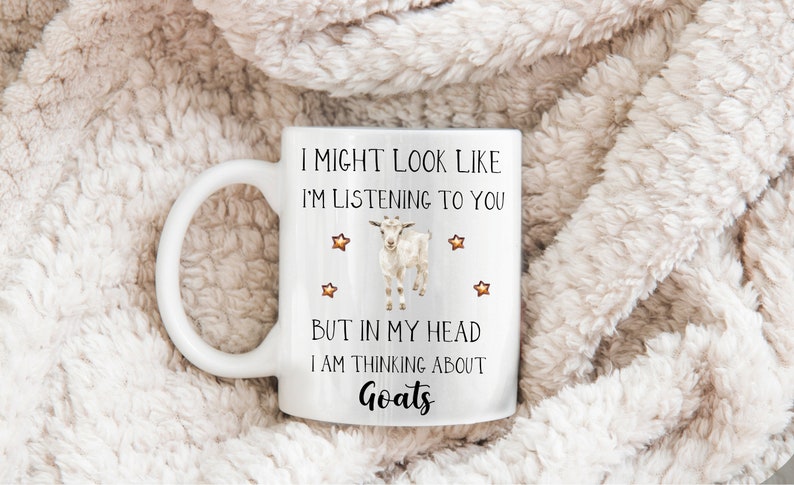 May include: White ceramic coffee mug with a black and white goat illustration and the text "I might look like I'm listening to you but in my head I am thinking about Goats".