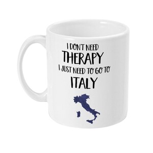 May include: White ceramic mug with black text that reads "I don't need therapy I just need to go to Italy" with a blue outline of Italy on the bottom.