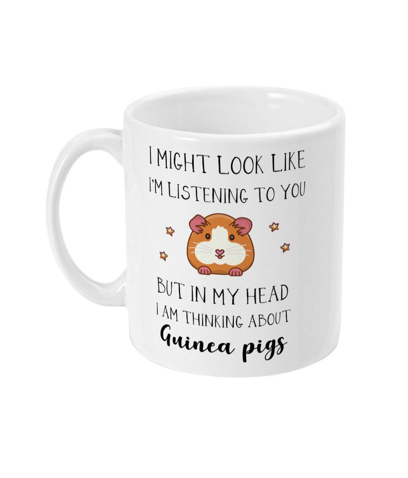 May include: White ceramic mug with a black and white illustration of a guinea pig and the text "I might look like I'm listening to you but in my head I am thinking about Guinea pigs".