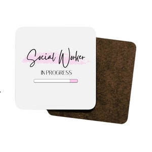 Puede incluir: Posavasos blanco con el texto "Social Worker" en escritura negra con un trazo de pincel rosa detr&aacute;s. Debajo del texto est&aacute; "IN PROGRESS" con una barra de progreso rosa.