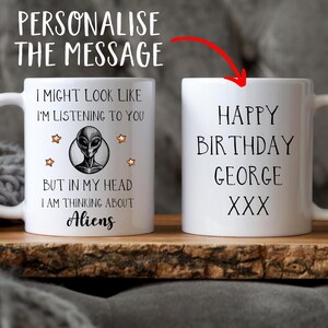 May include: White ceramic mug with a black alien graphic and the text "I might look like I'm listening to you, but in my head I am thinking about aliens". The other side of the mug has the text "Happy Birthday George XXX".