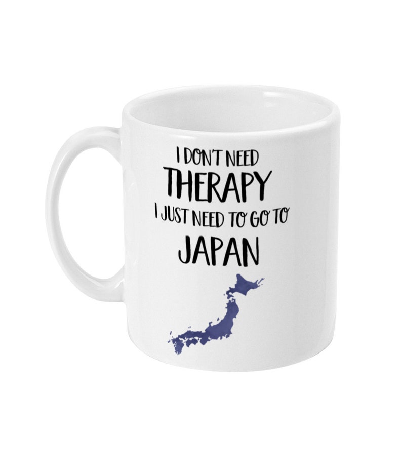 May include: White ceramic mug with a black and white graphic that says "I don't need therapy I just need to go to Japan" with a blue outline of the country of Japan.
