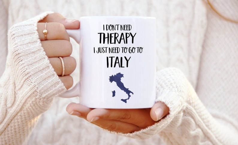 May include: White ceramic mug with black text that reads "I don't need therapy I just need to go to Italy" and a blue outline of the country of Italy.