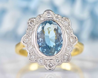 May include: A gold ring with a large oval aquamarine gemstone surrounded by a halo of smaller diamonds.