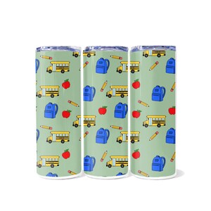 May include: Three stainless steel tumblers with a repeating pattern of yellow school buses, blue backpacks, red apples, and yellow pencils on a light green background. The tumblers have a silver rim and lid.