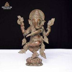 Könnte beinhalten: Eine Bronzestatue der hinduistischen Gottheit Ganesha, die in einer tanzenden Pose mit vier Armen dargestellt ist. Die Statue ist aufwendig mit floralen Mustern verziert und steht auf einem Lotussockel.