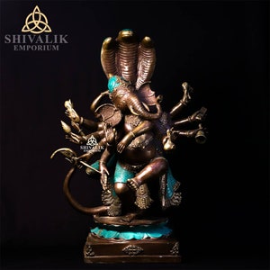 Könnte beinhalten: Eine Bronzestatue von Ganesha, dem hinduistischen Gott der Weisheit und des Wohlstands, mit mehreren Armen und einer Schlangenhaube. Die Statue ist mit türkisfarbenen und goldenen Akzenten verziert.