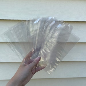 May include: A stack of clear plastic sleeves with holes for a binder. The sleeves are designed to hold papers or other documents.