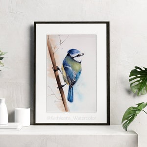 Puede incluir: Pintura acuarela de un carbonero com&uacute;n posado en una rama. El p&aacute;jaro est&aacute; pintado en tonos de azul, verde y blanco. El fondo es un suave lavado de azul y blanco.