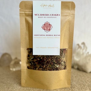 Könnte beinhalten: Ein brauner Papierbeutel mit einem weißen Etikett, auf dem "Higher Waves Apothecary" und "Muladhara Chakra Root of Existence" steht. Das Etikett zeigt auch ein rotes und weißes Symbol und den Text "Grounding Herbal Blend Red Raspberry Leaf Red Clover Hibiscus 100% Organic Artisanal Tea".