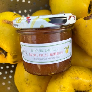 May include: A small glass jar of quince cheese, labeled "Helen's Jams and Jellies Quince Cheese - Membrillo Made with handpicked Shropshire quinces". The jar is surrounded by yellow quince fruit.
