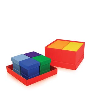 May include: A set of colorful gift boxes in a red tray. The boxes are in shades of blue, green, and purple. Another red box contains orange and yellow items. The boxes are arranged on a white background.