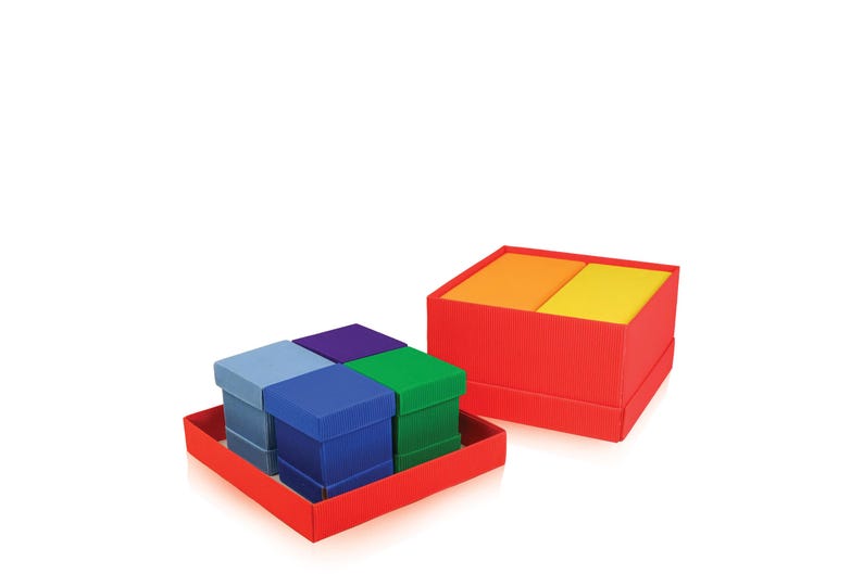 May include: A set of colorful gift boxes in a red tray. The boxes are in shades of blue, green, and purple. Another red box contains orange and yellow items. The boxes are arranged on a white background.