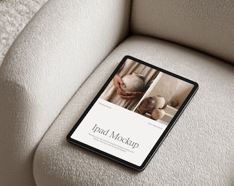 Op de afbeelding: Een zwarte iPad-mockup met een wit scherm met de tekst "Ipad Mockup" en afbeeldingen van aardewerk. De tablet ligt op een crèmekleurige, getextureerde fauteuil. De algehele esthetiek is minimalistisch en modern.