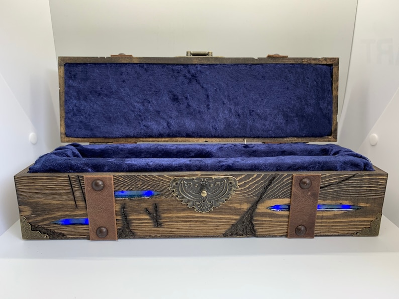 May include: A wooden box with a blue velvet interior and metal accents. The box has a distressed finish and features blue resin accents.