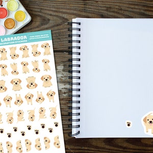 May include: A sheet of planner and decoration stickers featuring a variety of adorable yellow Labrador Retriever puppies in different poses. The stickers are printed on white paper with a blue border and the text "Happy Labrador Planner & Decoration Stickers" at the top.  Find more on Etsy @melissastevenson.