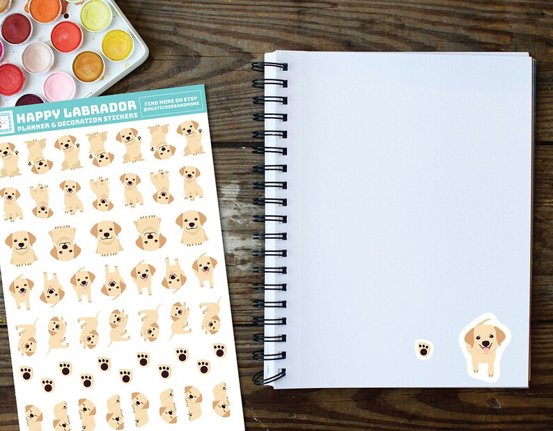 May include: A sheet of planner and decoration stickers featuring a variety of adorable yellow Labrador Retriever puppies in different poses. The stickers are printed on white paper with a blue border and the text "Happy Labrador Planner & Decoration Stickers" at the top.  Find more on Etsy @melissastevenson.