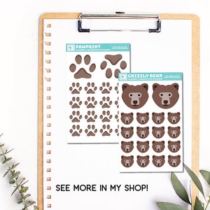 Puede incluir: Dos hojas de pegatinas para planificadores y decoraci&oacute;n. Una hoja presenta huellas de patas marrones sobre un fondo blanco. La otra hoja presenta caras de osos grizzly marrones sobre un fondo blanco. El texto "PAWPRINT" y "GRIZZLY BEAR" est&aacute; impreso en las hojas. El texto "SEE MORE IN MY SHOP!" est&aacute; impreso debajo de las hojas.