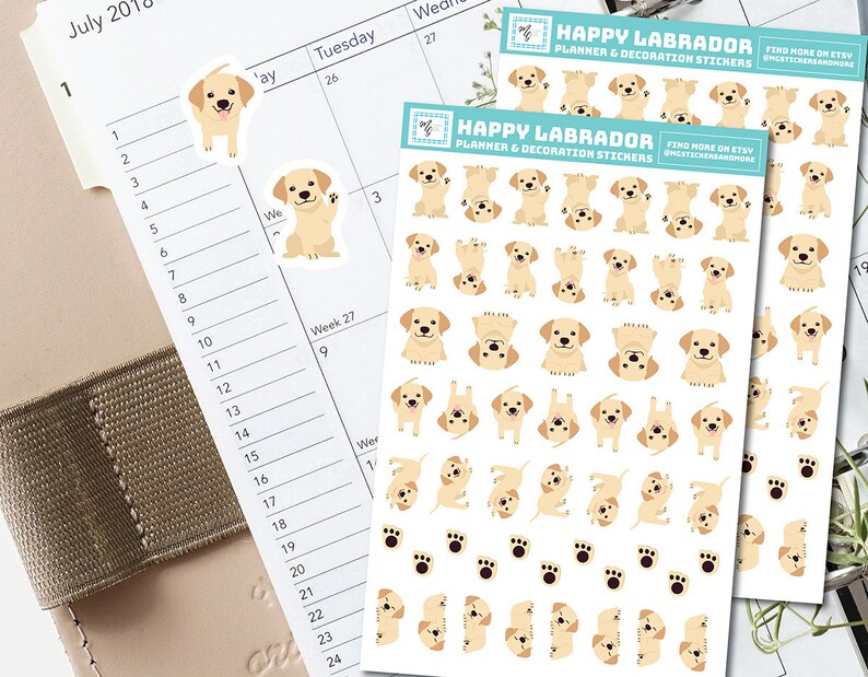 May include: A sheet of planner stickers featuring adorable Labrador Retriever illustrations. The stickers are white with a light yellow background and feature various poses of the dogs, including sitting, standing, and playing. The text "HAPPY LABRADOR PLANNER & DECORATION STICKERS" is printed at the top of the sheet.