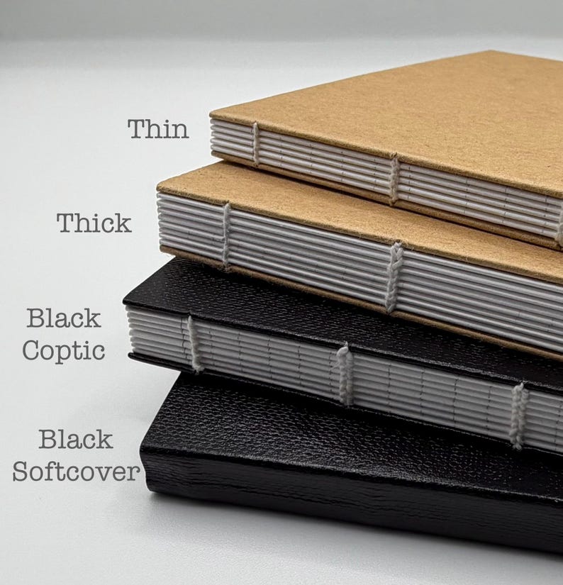 K&ouml;nnte beinhalten: Ein Stapel handgefertigter Notizb&uuml;cher mit sichtbaren N&auml;hten. Die oberen beiden Notizb&uuml;cher haben braune Umschl&auml;ge, beschriftet mit "Thin" und "Thick". Die unteren beiden Notizb&uuml;cher sind schwarz, beschriftet mit "Black Coptic" und "Black Softcover".