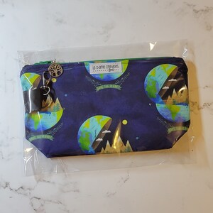 May include: A blue zippered pouch with a green zipper and a green trim. The pouch has a repeating pattern of green and blue globes with the text "Save the Planet" on each globe. The pouch also has a small, brown tree charm attached to a silver key ring.