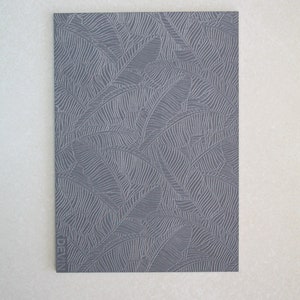 May include: A grey card with a textured pattern of leaves. The word "DEVIN" is printed on the bottom left corner of the card.