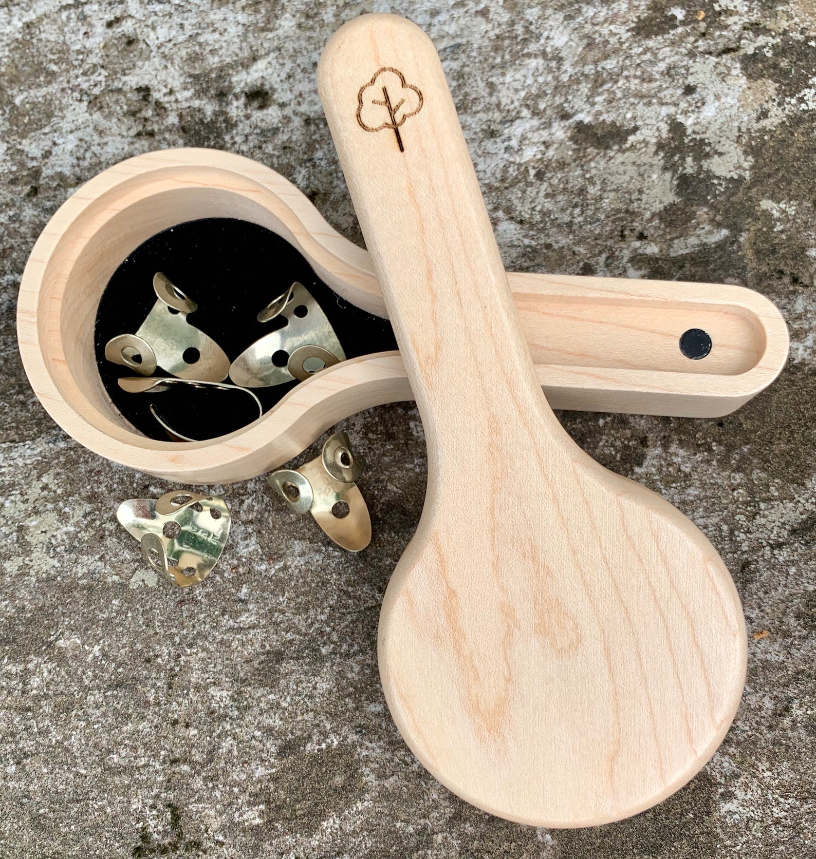 small wooden box shaped like a banjo with banjo picks in it