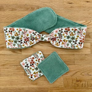 Può includere: Una fascia per spa in spugna verde acqua con un fiocco a fantasia floreale e due dischetti per il viso abbinati. I dischetti hanno una fantasia floreale su un lato e spugna verde acqua sull'altro.