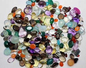 May include: A large assortment of colourful gemstones, including amethyst, citrine, agate, and carnelian. The gemstones are various shapes and sizes, and are perfect for jewellery making or crafting.