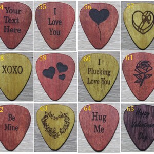 Puede incluir: Una colecci&oacute;n de p&uacute;as de guitarra de madera con varios dise&ntilde;os y textos grabados. Los dise&ntilde;os incluyen corazones, rosas, notas musicales y frases como "I Love You", "XOXO" y "Happy Valentine's Day". Las p&uacute;as son en tonos de rojo, marr&oacute;n y dorado.