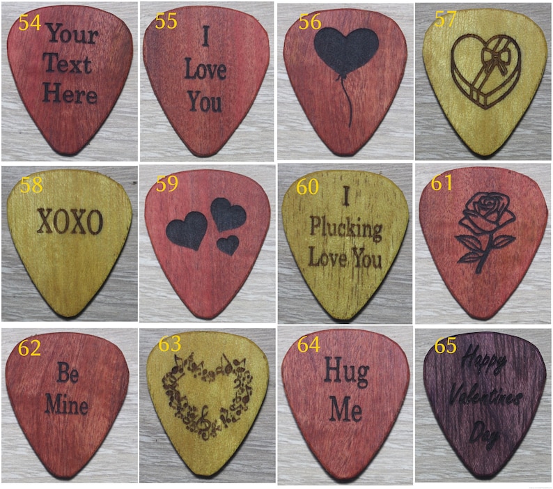 Puede incluir: Una colecci&oacute;n de p&uacute;as de guitarra de madera con varios dise&ntilde;os y textos grabados. Los dise&ntilde;os incluyen corazones, rosas, notas musicales y frases como "I Love You", "XOXO" y "Happy Valentine's Day". Las p&uacute;as son en tonos de rojo, marr&oacute;n y dorado.