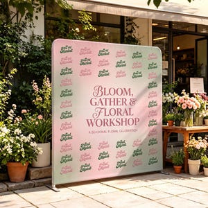 May include: A large rectangular backdrop stand featuring a pink and white gradient background with a repeating pattern of the text Petal Market in green and pink. The center displays the text Bloom, Gather & Floral Workshop A Seasonal Floral Celebration.