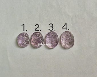 Könnte beinhalten: Vier ovale, geschnitzte Edelsteine in verschiedenen Lavendeltönen. Jeder Stein hat ein einzigartiges Blumen- oder abstraktes Design. Die Edelsteine sind mit 1 bis 4 nummeriert, wobei der Name des Verkäufers, jadigemsart, sichtbar ist.