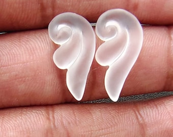 May include: A pair of clear glass angel wing earrings. The wings are detailed and have a frosted finish.